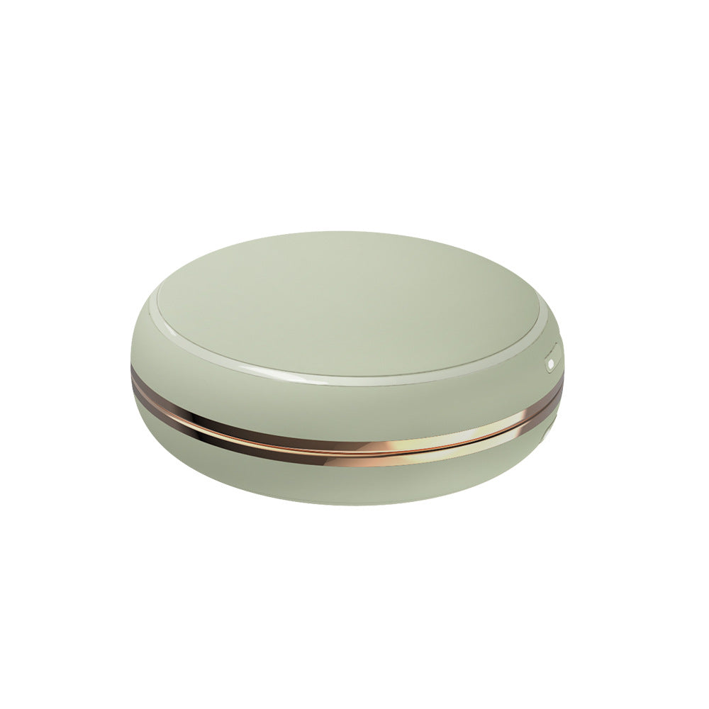Round rechargeable hand warmer held in a hand